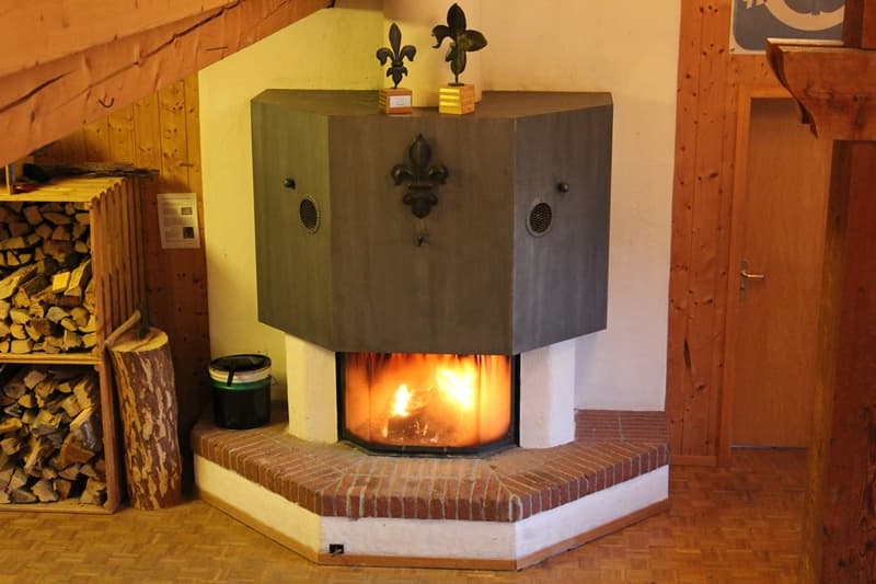 Cheminée mit brennendem Feuer und Holzbeige