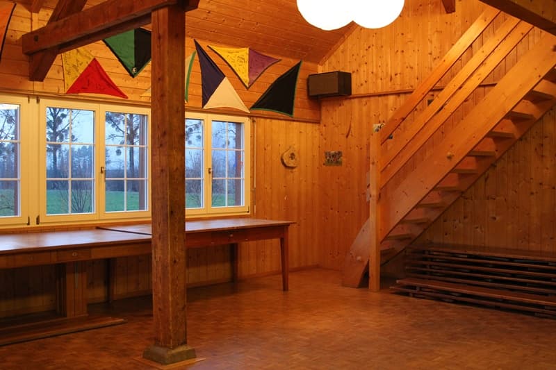 Aufenthaltsraum mit Holzdecke und grossen Fenstern
