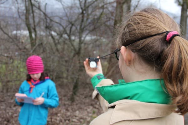 Zwei Kinder mit Kompass und Notizblock im Wald