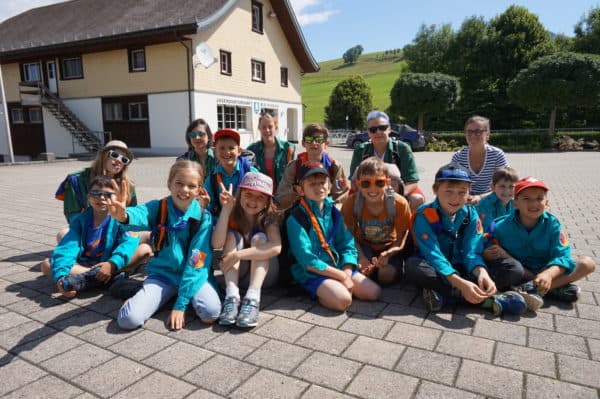 Gruppe von Kindern in blauen Pfadijacken vor einem Haus